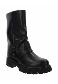 Bota negra de media caña hecha de cuero liso con un diseño relajado. Presenta una suela gruesa y con relieve, y una etiqueta con el logo en el tobillo.