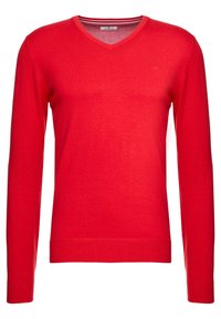 Maglione rosso con scollo a V in un materiale a maglia liscia, con maniche lunghe e polsini e orlo a coste. Branding minimal nella zona del petto.