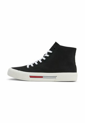 Zapatillas altas de lona negras con cordones blancos, suela de goma y una franja de color rojo y blanco a lo largo del mediopie.