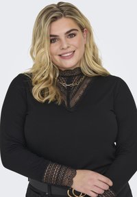 Black long-sleeve top featuring a lace neckline and lace-trimmed cuffs, with a ribbed texture and a fitted silhouette.