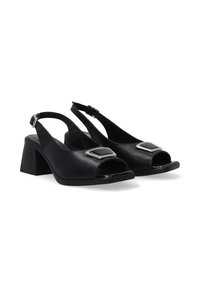 Schwarze Leder-Slingback-Absätze mit einem Blockabsatz, offenem Zehenbereich und glänzendem Silberakzent an der Vorderseite. Glatte Textur mit einem sicheren Riemenverschluss.