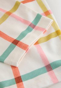 Puuvillane kangas kreemika taustaga, millel on mitmevärviline ruuduline muster roosas, piparmündirohelises, oranžis ja kollases. Sile tekstuur.