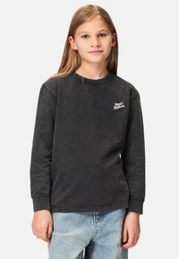 Musta pitkähihainen puuvillapaita, jossa on pyöreä pääntie ja ribbausrannekkaita, ja vasemmalla puolella valkoinen brodeerattu logo.