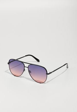 Gafas de sol de metal negro con una forma angular de aviador y lentes degradados que transicionan de púrpura a rosa. Presentan almohadillas nasales ajustables.