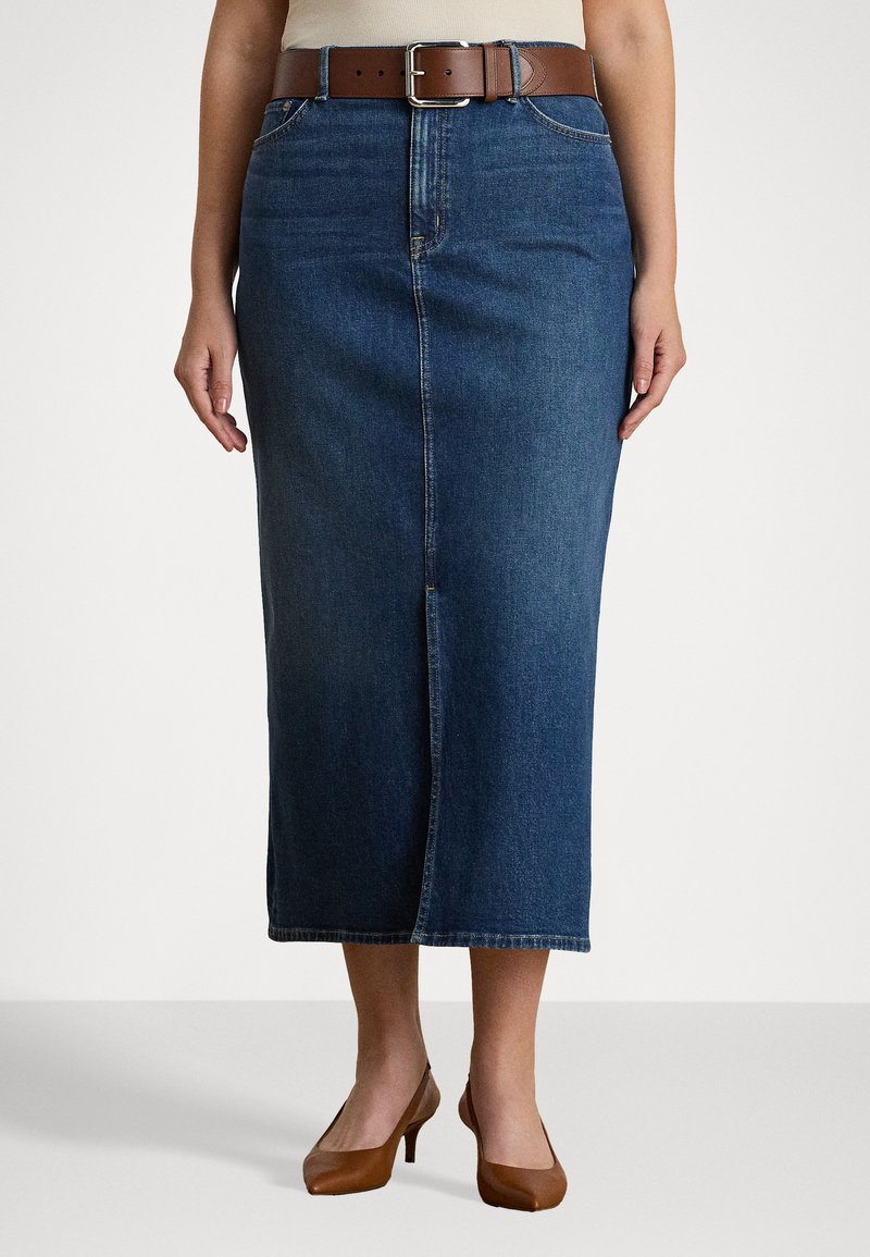 Mørkeblå denimskjørt i mid lengde med en frontspalte. Kombinert med et brunt belte og brune høye hæler, med en glatt tekstur.