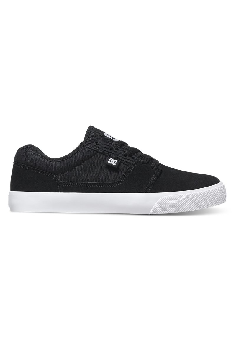 Čierne skateboardové topánky vyrobené z semišu a textílie, s nízkym profilom, bielou gumovou podrážkou a textúrovanou špičkou. Logo na boku.