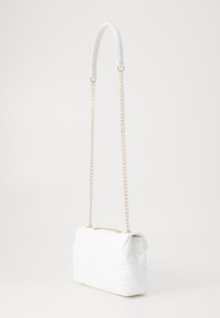 Borsa a spalla trapuntata bianca con tracolla in oro e un design liscio e strutturato. Presenta una chiusura a patta e cuciture a motivo chevron.