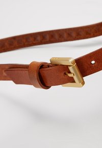 Cintura in pelle marrone con una superficie liscia, dotata di una fibbia in metallo dorato e un design semplice e minimalista.