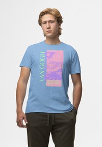 Camiseta de algodón azul claro con un diseño gráfico que presenta acentos en rosa y morado. El texto dice "VAN GOGH" junto a una escena ilustrada.
