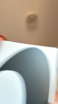 Biely dokument s hladkým povrchom, v strede sa nachádza veľký šedý abstraktný tvar. Pozadie je svetlé a jemné.