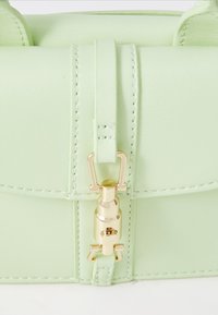 Mint green leather handbag with a structured shape, featuring a gold-tone clasp and stitching details. Small size with a smooth texture.