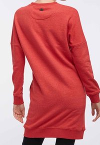 Robe sweat à manches longues, de couleur rouge, avec un ourlet arrondi et un détail de bouton au dos. Fabriquée en tissu doux et texturé.