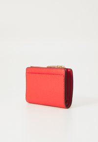 Portefeuille en cuir rouge avec une finition texturée, doté d'une fermeture éclair et de porte-cartes. Forme rectangulaire compacte avec des bords noirs contrastants.
