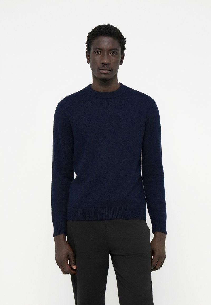 Navy blue knit sweater with a round neckline, long sleeves, and ribbed cuffs and hem. Soft texture with a minimalistic design.