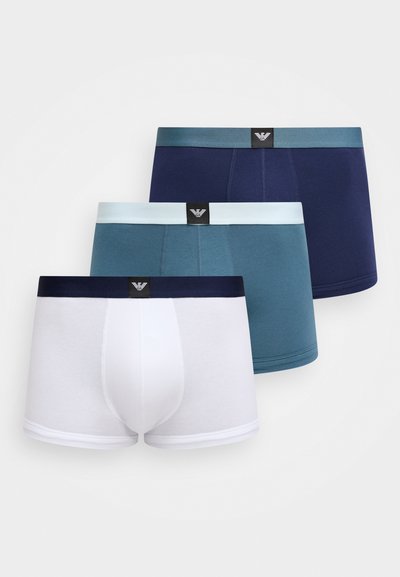 Trois paires de boxers en blanc, bleu sarcelle et marine, avec des ceintures élastiques affichant des logos de marque. Tissu en coton doux et coupe ajustée.