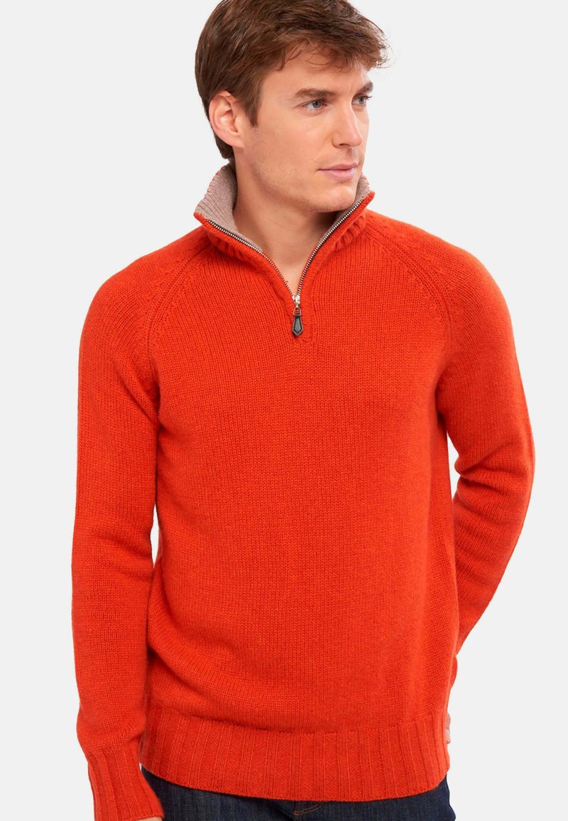 Roter Strickpullover mit einem Reißverschlusskragen, der ein heller gefärbtes Innenfutter sowie gerippte Bündchen und Saum aufweist.