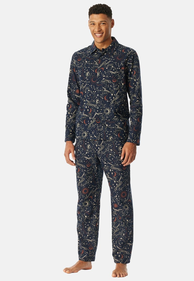 Conjunto de pijama en color marino con un patrón celestial de estrellas y lunas. Fabricado en tejido suave, incluye una camisa de botones y pantalones con cintura elástica.