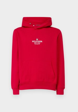 Czerwona bluza z kapturem, przednią kieszenią i małymi zatrzaskami na kapturze, z białym napisem "Hilfiger New York" i logo na piersi.