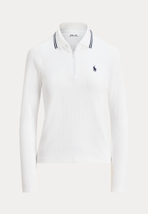 White long-sleeve polo with a textured cable-knit design, zip collar, and two navy stripes. Features a small navy logo on the left chest.