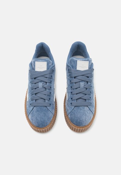 Baskets en suede bleu avec bout arrondi, lacets ton sur ton, col rembourré et semelle en caoutchouc. Présente un patch de marque sur la languette et une semelle en caoutchouc texturée.