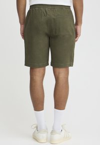 Žalios spalvos medvilniniai šortai su elastine juosmens dalimi, priekinėje dalyje yra kišenė. Audinys yra švelnus ir turi laisvą, patogų kirpimą.