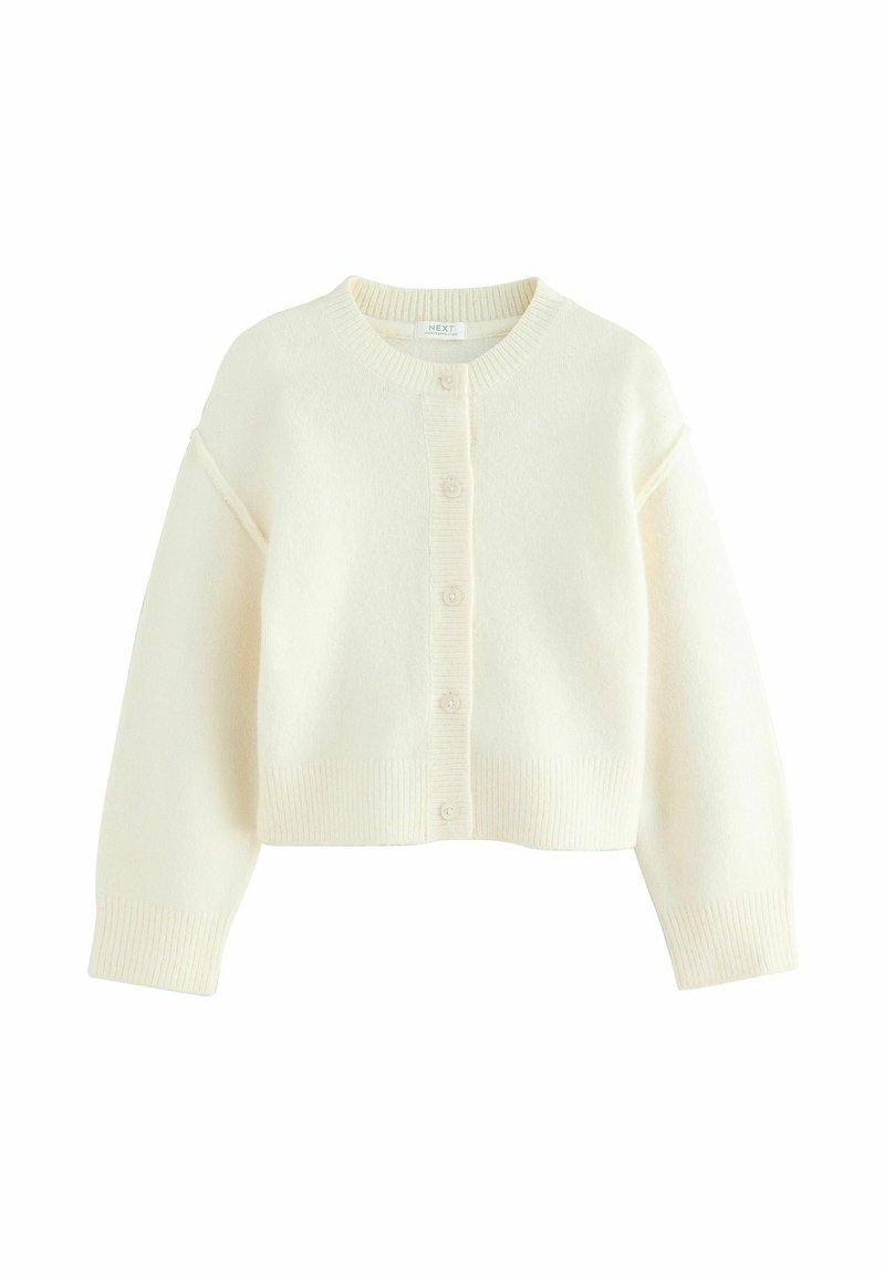 Cardigan court couleur crème en matériau doux, avec un col rond, six boutons sur le devant et des poignets et un ourlet côtelés.