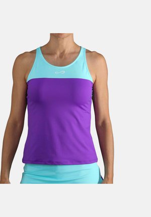 Vrouw draagt mouwloze sporttop met lichtblauw bovenstuk en paarse onderkant, staande tegen een effen achtergrond.