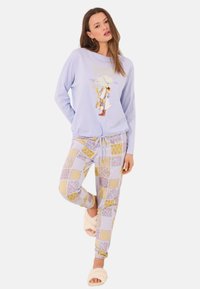 Lichtblauw langemouwen top met grafisch ontwerp en tekst, gecombineerd met gestreepte pyjamabroek in pastelkleuren. Zachte stof, relaxte pasvorm.
