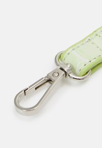 Jasnozielony, teksturowany pasek z srebrną metalową klamrą. Posiada gładką, błyszczącą powierzchnię oraz widoczne przeszycia wzdłuż krawędzi.