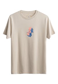 Beige katoenen t-shirt met een grafische print van twee op elkaar gestapelde huizen in blauw en roze. Korte mouwen en een ronde hals.
