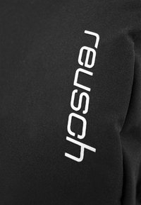 Schwarzes Stofftäschchen mit weißem Text "Reuse" vertikal auf einer Seite. Glatte Textur, minimalistisches Design, keine sichtbaren Beschläge oder Muster.