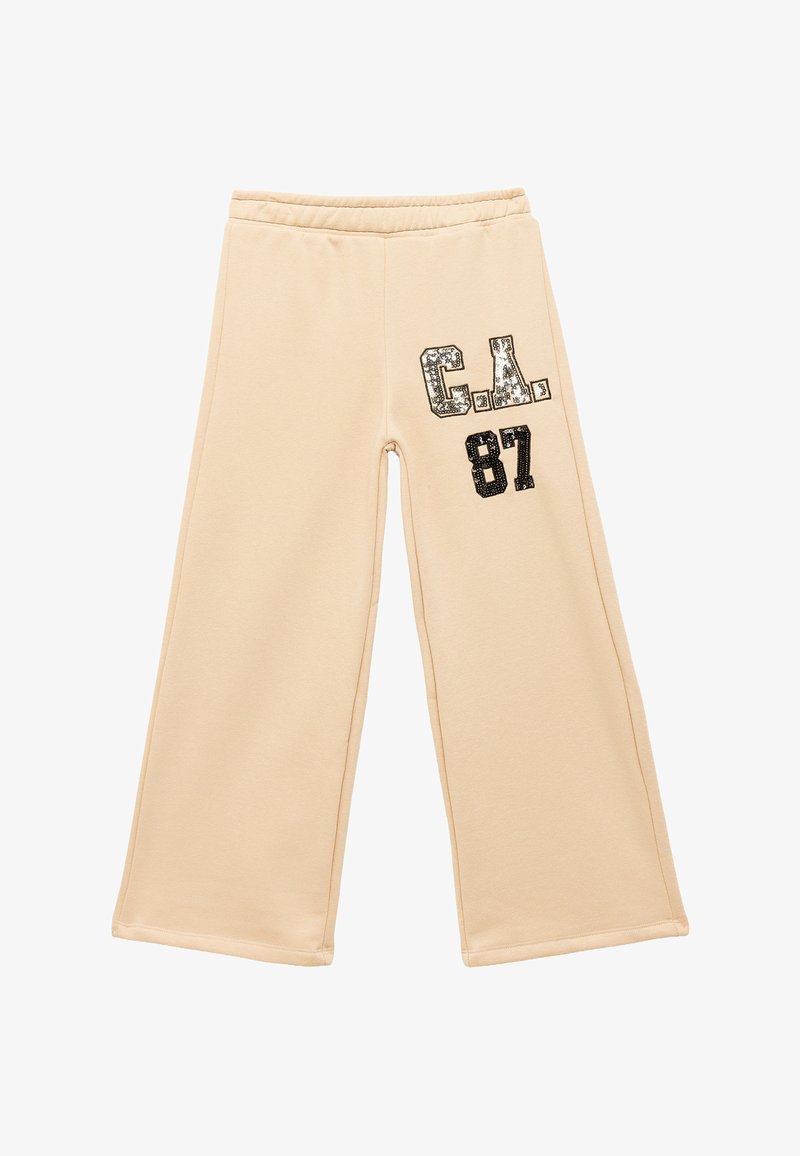 Beige, weit geschnittene Sweatpants mit einem elastischen Bund. Auf der linken Vorderseite befindet sich glänzender schwarzer Pailletten-Schriftzug "C.A. 87". Glatte Textur.