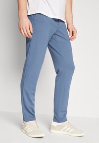 Hellblaue Jogginghosen aus weichem Stoff, mit schmalem Schnitt, elastischem Bund, seitlichen Taschen und glatter Textur.