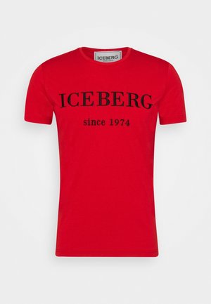 Punainen puuvillainen t-paita lyhyillä hihoilla, pyöreä kaula-aukko, jossa on iso musta "ICEBERG" -teksti ja "since 1974" alla. Sujuva pinta.