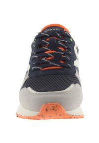 Sneaker a rete navy con accenti in suede grigi e dettagli arancioni. Presenta una suola testurizzata con motivi arancioni puntinati e lacci multicolori.