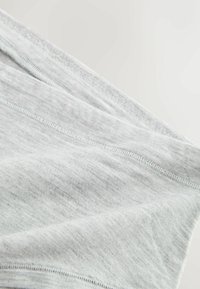 Material din bumbac gri deschis cu textură moale și detalii de cusături vizibile, aranjat în pliuri pentru a evidenția căderea și suprafața sa.