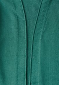 Türkiser Strickcardigan mit texturiertem Stoff, V-Ausschnitt und sichtbaren Nähten entlang der Kanten, die einen offenen Frontstil schaffen.
