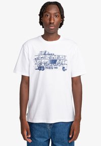 White cotton T-shirt featuring a blue graphic of a bus with cartoon characters and "ELEMENT PARIS" text, short sleeves, and a crew neck.