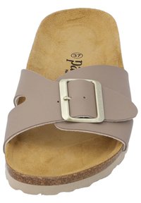 Tan klädsandal med en texturerad mockainnersula, slät syntetisk ovandel och en metallspänne. Har en korkliknande mellansula och en flexibel yttersula.