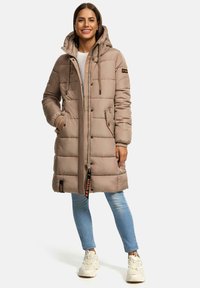 Beige puffjacka med huva, quiltat mönster, dragkedja och tryckknappar. Har sidofickor och en orange logotypdetalj vid nederkant.