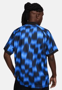 Korte mouw shirt in een blauw gradient patroon op een zwarte basis, met een textuurstof en zwarte afwerking bij de kraag en mouwen.