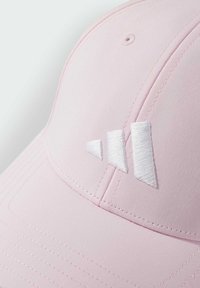 Růžová čepice se strukturovaným designem, hladkým povrchem a bílým vyšitým logem se třemi pruhy. Doplňky zahrnují prošité švy a ventilační otvor.