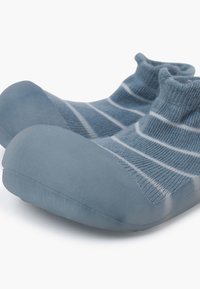 Scarpe blu slip-on con punta in gomma e tomaia in tessuto lavorato a maglia caratterizzata da righe blu e bianche. Texture morbida e forma arrotondata.