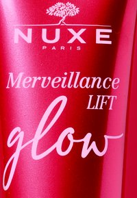 Ljusrosa cylindrisk tube med matt yta, med vit text; inkluderar varumärket "NUXE PARIS" och produktinformation.