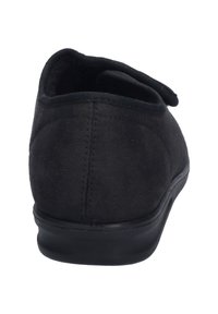 Scarpa in suede nera con un design a profilo basso e un retro arrotondato. Presenta una tomaia testurizzata e una suola in gomma liscia. Cinturino regolabile nella parte superiore.