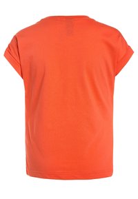 Koszulka z krótkim rękawem i okrągłym dekoltem w jaskrawym pomarańczowym kolorze, wykonana z bawełny. Charakteryzuje się luźnym krojem i podwiniętymi rękawami; gładka faktura bez widocznych wzorów.