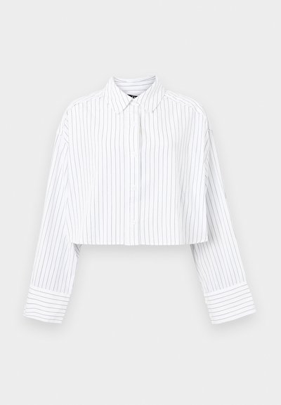 Camisa branca cortada com riscas verticais em azul-marinho, frente com botões, colarinho pontudo e punhos largos. Feita de um tecido leve e suave.