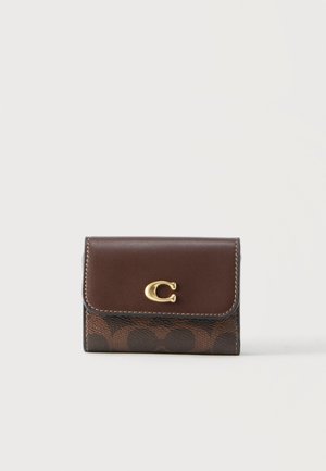 Portofel mic maro din piele cu emblemă aurie în formă de "C" și modelul semnătură din pânză acoperită pe față, pe un fundal simplu.