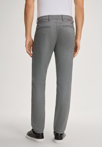 Grijze broek met een gestreept patroon en een rechte pasvorm, met achterzakken en een taillebanddetail, in combinatie met zwarte sneakers.
