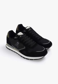Zapatillas negras con un upper texturizado, que presentan un diseño de calavera y tibias cruzadas, acentos grises y una entresuela blanca. Atadas con cordones negros.